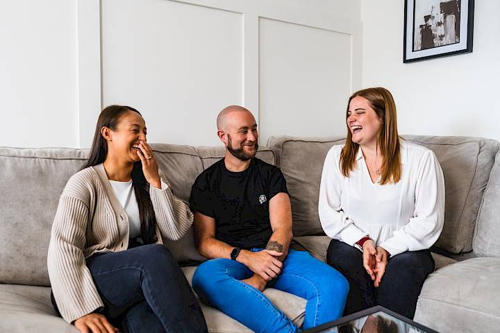 Guests laughing on sofa