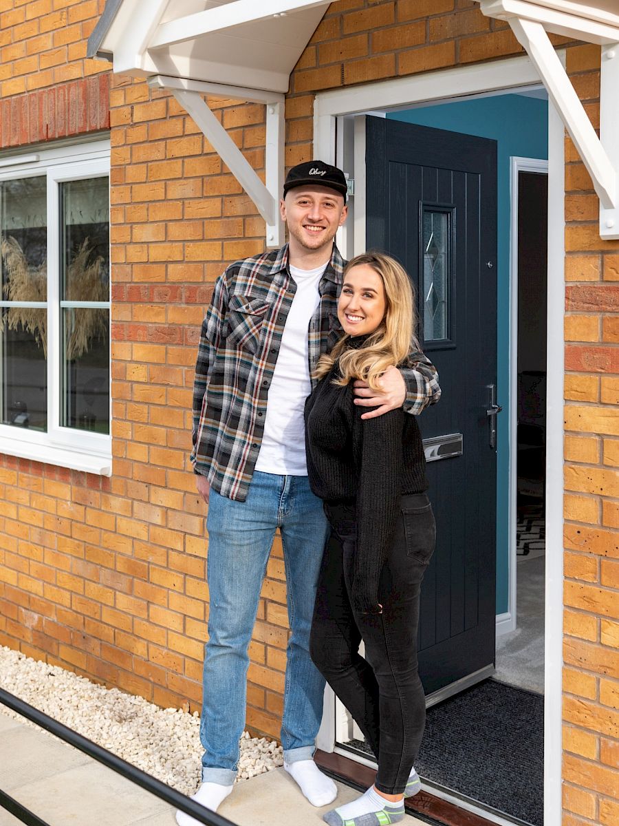 Happy couple standing in doorway.