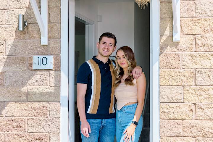 Happy couple standing in doorway.